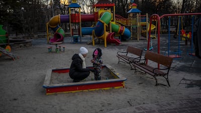 Olga plays with her daughter Vedeneya in an empty park in Kyiv. AP