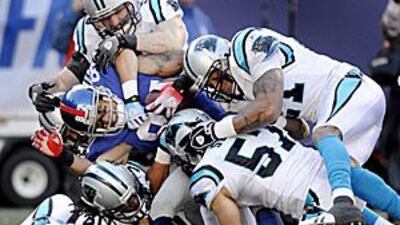 The Giants' Domenik Hixon, in dark blue, is gang-tackled by Carolina Panthers players in the New Yorkers' final game at Giants Stadium.