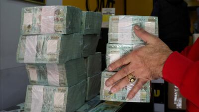 A money exchange vendor holds Lebanese pound banknotes at a shop in Beirut, Lebanon. Reuters