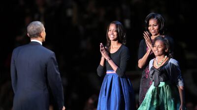 Barack Obama is met on stage by first lady Michelle Obama and daughters Sasha and Malia after his victory speech. Spencer Platt / AFP
