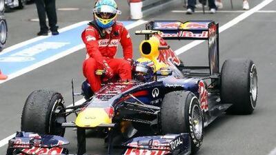 Fernando Alonso, left, enjoys a lift back to the pit lane at the Nurburgring on the side of Mark Webber's Red Bull Racing car.