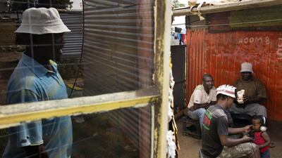 Striking miners idle in the backyard of a shack in Marikana. An entry-level Lonmin worker earns 5,713 rand basic salary a month, but extra allowances and benefits push the package to 9,790 rand. Marco Longari / AFP