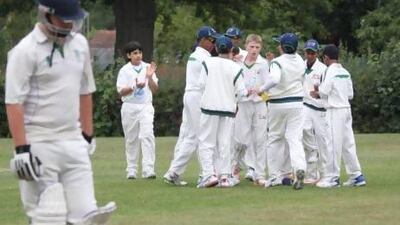 Patrick Kilding, centre of the huddle, is congratulated for a wicket in the game against Dorset at the Ardingly College grounds. Amith Passela / The National