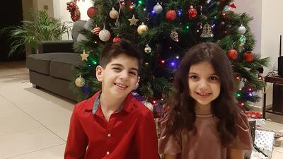 Dima Maroun's children in front of their Christmas tree in Dubai. Ms Maroun bought the tree when she lived in Jordan 12 years ago. Photo: Dima Maroun.