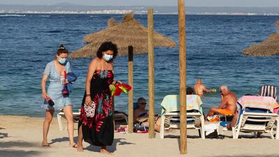 Tourists walk at Palmanova Beach on the Island of Mallorca on July 27, 2020. The UN has said there's no time for "timid leadership" as the safe restart of tourism is possible. AFP.