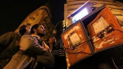Egyptians watching Al Jazeera on a set placed on top of public telephone booths in Cairo's Tahrir Square, during the demonstrations earlier this year calling for the removal of President Hosni Mubarak's regime. Khaled Desouki / AFP Photo