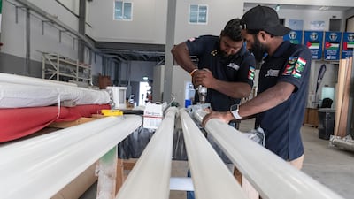 Workers at Trident Support preparing flagpoles.