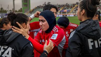 Azizi Khursand of Afghanistan, centre, in the huddle before the Fifa Unites match between Afghan Women United and Tunisia. AFP