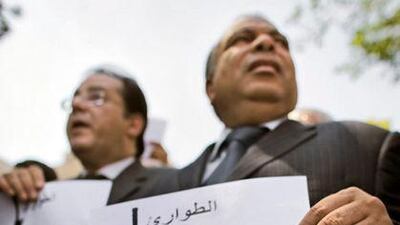 The opposition politician Ayman Nour, left, and another demonstrator hold banners showing a noose labelled "emergency" hanging over a skeleton named "the people of Egypt".