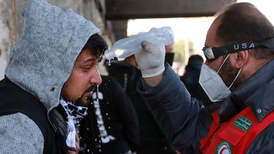 A paramedic helps an Iraqi protester who was affected by tear gas, which was dispensed by riot police during clashes following a protest at the Al-khilani square in central Baghdad. EPA