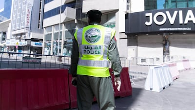 Police officers patrol barricades preventing access to the gold souq and buildings inside the quarantine zone