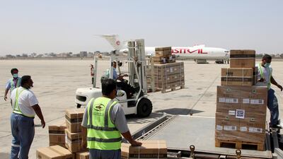 Workers handle the first batch of doses of the AstraZeneca vaccine at Aden International Airport, Yemen. Reuters