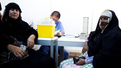 Amena Mohammed, 51, left, and Fatemeh Nejad, 72, right, have their blood pressure checked at a free Red Crescent medical clinic, where police had to be called in for crowd control.