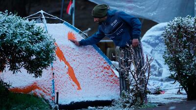 A Iraqi demonstrator wipes the snow off his tent in Tahrir Square. AP Photo