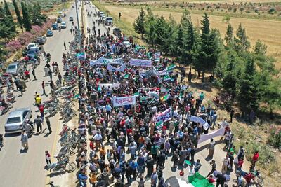 Syrian protesters displaced from their homes gather outside a Turkish army base near Idlib to demand that the Turks fulfil their side of a truce agreement and allow them to return to their homes. Omar Haj Kadour / AFP