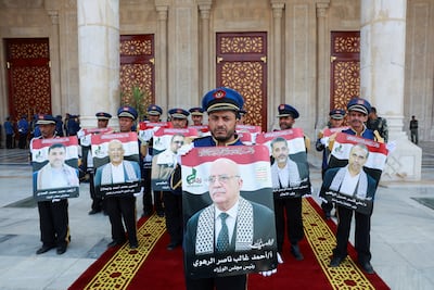 Honour guards hold photos of the dead government officials during the funeral in Sanaa. Reuters
