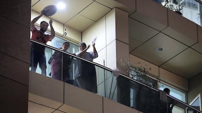 UAE residents cheering from their balconies and homes on Wednesday night at Al Mankhool area in Bur Dubai. Pawan Singh / The National