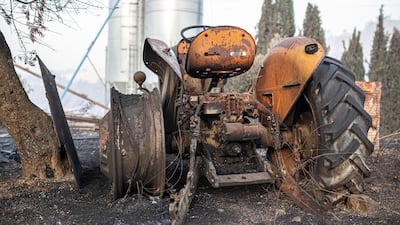 A burned farm tractor lays destroyed after a wildfire swept through Torre de l'Espanyol. AP Photo