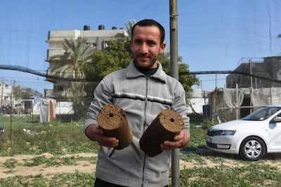 Mohammad El Gha, 31, holds two olive peel blocks in Khan Yunis, southern Gaza. Rosie Scammell for The National