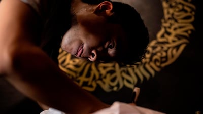 This photo taken on June 22, 2019 shows artist Taipan Lucero doing calligraphy using the indigenous script known as Baybayin, used before Spanish colonisation in 1521, at an event in Manila.