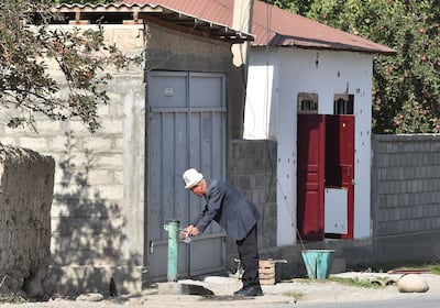 A man collects water near a damaged house in the village of Ak-Say near the Kyrgyz-Tajik border, some 1000 kilometres from Bishkek, on September 20. AFP