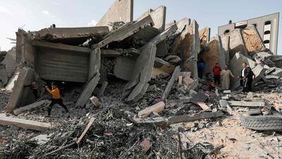 Palestinian men on May 6, 2019, gather amidst the rubble of a building that was destroyed during Israeli air strikes on Gaza City. AFP