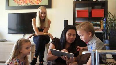Leny Alzaga, centre, a Filipina housemaid, with her employers Joanna Robinson, second left, and children Summer and Chase Robinson, inside their home at Jumeirah Beach Residence in Dubai.