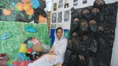 Karren Jamir sits next to her sculpture, Suffocation, which she says was inspired by decrees issued when the Taliban ruled Afghanistan in the 1990s.