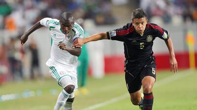Osvaldo Rodriguez, right, and his Mexico teammates could not run away from Man of the Match Musa Muhammed, left, and Nigeria. Marwan Naamani / AFP