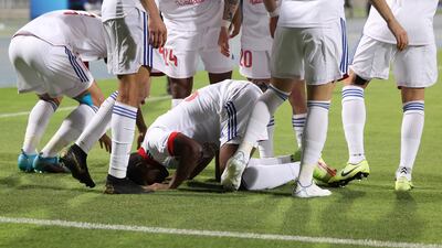 Sharjah forward Ousmane Camara celebrates his opening goal with teammates.