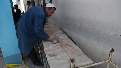 An Afghan member of medical staff cleans a stretcher following a suicide bombing attack at the Isteqlal Hospital in Kabul on April 22, 2018. Wakil Kohsar / AFP