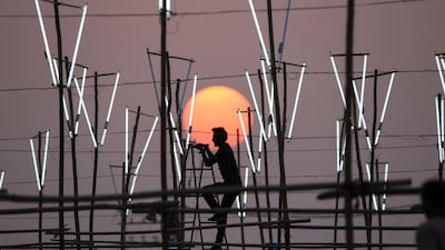 A worker installs lights at an outdoor location for a film shoot in Bhopal, India. AFP