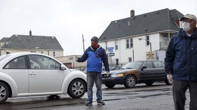 Community organizer Nazel Huda directs traffic while volunteers place donated food items into the cars of people in need on the first day of Ramadan in Hamtramck, Michigan. Getty Images via AFP