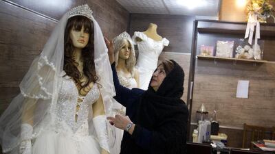 Iranian woman fixing the dress on mannequin in her store in Tehran on Jan 9, 2014. Maryam Rahmanian for The National