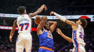 New York Knicks centre Mitchell Robinsons gets double teamed by Philadelphia 76ers players VJ Edgecombe and Dominick Barlow.