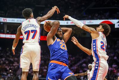 New York Knicks centre Mitchell Robinsons gets double teamed by Philadelphia 76ers VJ Edgecombe and Dominick Barlow during the NBA Abu Dhabi match at Etihad Arena. Victor Besa / The National