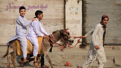 Children enjoy riding a roadside donkey during Eid Al Fitr celebrations in Peshawar, Pakistan. EPA