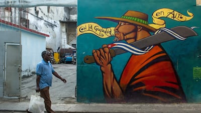 A Cuban walks by a graffiti of street art in Havana, on July 12, 2017. / AFP PHOTO / YAMIL LAGE