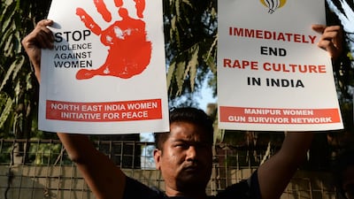 This photo taken on February 21, 2017 shows an Indian social activist holding placards during a protest against a rape at Hauz Khas village in New Delhi. Sajjad Hussain / AFP