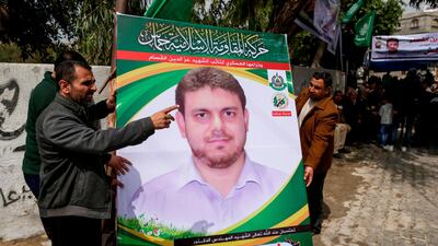 Men hold up a poster of 35-year-old Palestinian professor Fadi Al Batsh, who was killed on April 21 in Kuala Lumpur, Malaysia. (AFP)