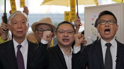 Chu Yiu-ming, left, Benny Tai and Chan Kin-man shout slogans before entering a court in Hong Kong. AP Photo