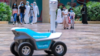 A robot carries out temperature checks of shoppers at Aldar Properties' Yas Mall. The developer has extended about Dh190m to retail tenants and schools customers since the onset of Covid-19. Victor Besa /The National
