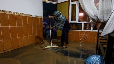 A woman sweeps water from a flooded house in Sulaymaniyah in Iraq’s Kurdistan region