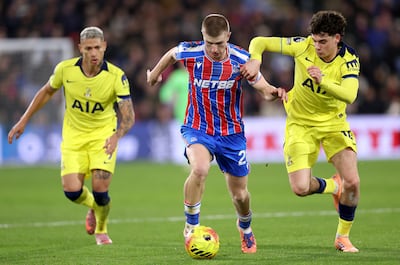 Adam Wharton, centre, of Crystal Palace runs with the ball whilst under pressure from Archie Gray of Tottenham Hotspur, right. Getty Images