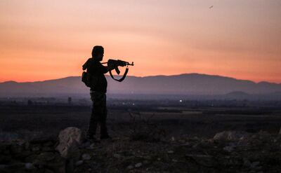 A Syrian rebel fighter aims his Kalashnikov assault rifle as he stands near the frontline against government forces west of the embattled southern city of Deraa. AFP