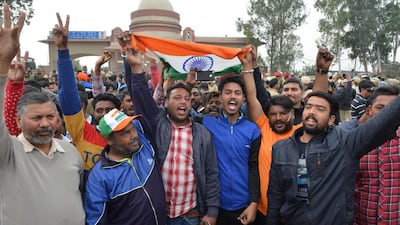 Indian men shout slogans and wave the national flag near the India-Pakistan border in Wagah on March 1, 2019, as they wait for the return of an Indian Air Force pilot being returned by Pakistan. Pakistan was set to free a captured Indian pilot on March 1 in a "peace gesture" aimed at lowering temperatures with its nuclear arch-rival, after rare aerial raids ignited fears of a dangerous conflict in South Asia. AFP
