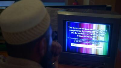 A viewer in Islamabad looks at a television screen flashing a suspension of service notice on the GEO News channel on June 6, 2014. B K Bangash / AP Photo
