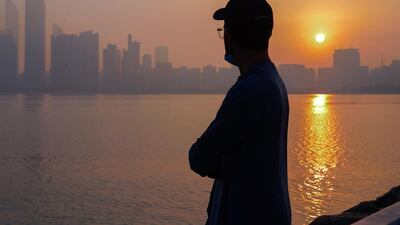 Mohammad Al Ahli finds solace watching the sunrise on a foggy Wednesday morning at the Corniche. Victor Besa / The National