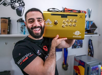 Al Shalabi with the gold arcade controller commemorating his Street Fighter 6 victory at Evo 2023. Victor Besa / The National