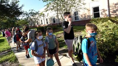 Students wearing face masks arrive with their parents on the first day of classes for the 2021-22 school year at Baldwin Park Elementary School in Florida. Getty Images